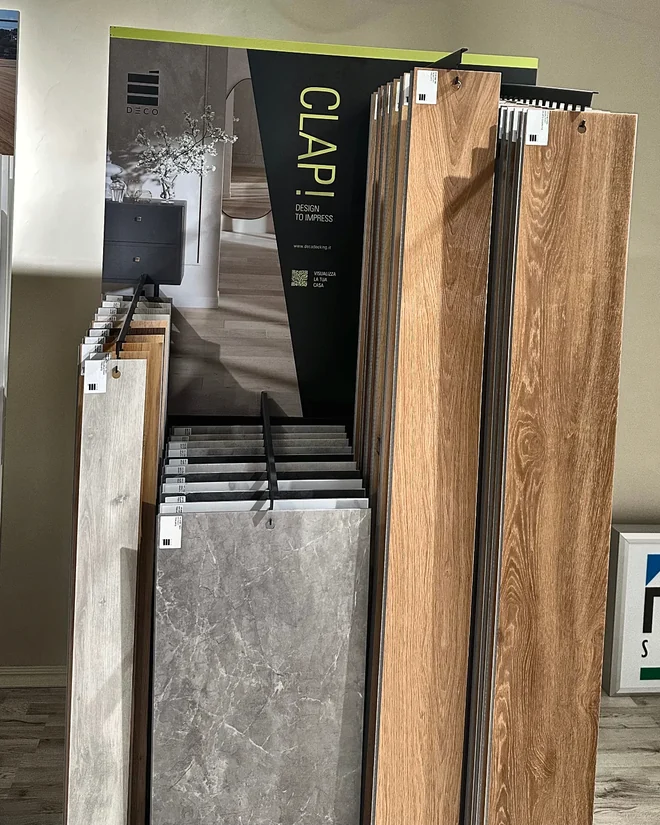Espositore pavimenti e rivestimenti nello showroom ArreDoor di Nardò: doghe effetto legno e effetto pietra, campionario colori